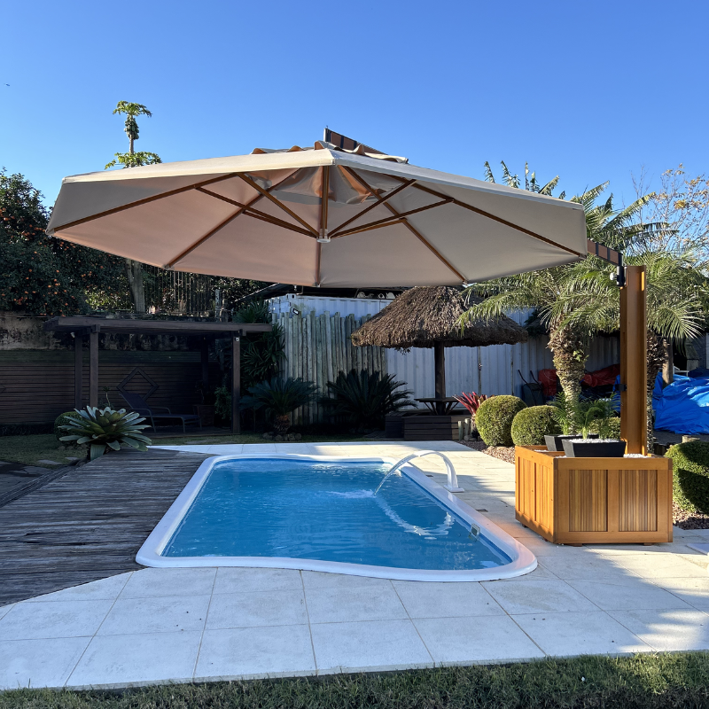 Ombrelone lateral com floreira ao lado da piscina
